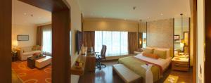 a hotel room with a bed and a desk at Vivanta Coimbatore in Coimbatore