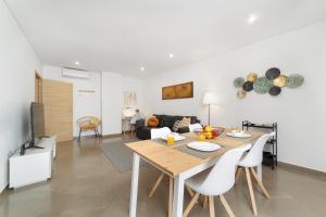 una sala da pranzo e un soggiorno con tavolo e sedie. di LUMO Apartment Fátima a Fátima