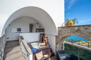 een huis met een dompelbad en een boog bij Albadamare Boutique Hotel in Praiano