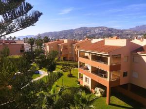 Blick auf ein Gebäude mit Palmen und Häusern in der Unterkunft Apartamento con la playa a 200 metros in Granada