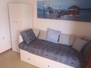 eine Couch in einem Zimmer mit Bild eines Piers in der Unterkunft Apartamento con la playa a 200 metros in Granada