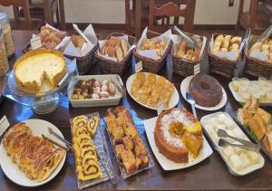 une table avec de nombreux desserts différents dans l'établissement Hotel Vila Bavária Petrópolis, à Petrópolis