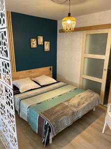 een slaapkamer met een bed en een blauwe muur bij Gîte des Restanques in Grasse