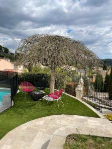 een groep stoelen onder een boom bij Gîte des Restanques in Grasse