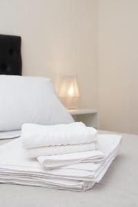 a stack of white towels sitting on a bed at Malanca - Nueva Córdoba in Cordoba