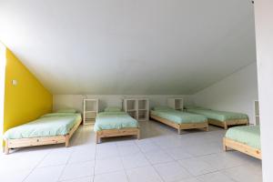 Cette chambre mansardée comprend 3 lits. dans l'établissement Pineapple Surf House, à Peniche