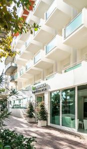 una imagen de un edificio con plantas delante de él en Hotel Lampara, en Lignano Sabbiadoro