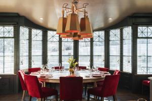 una sala da pranzo con un grande tavolo e sedie rosse di Hôtel Mont-Blanc Chamonix a Chamonix-Mont-Blanc