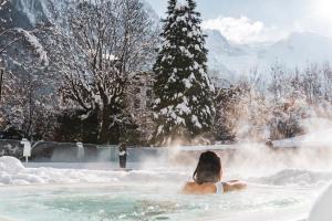 Una donna in una vasca idromassaggio nella neve di Hôtel Mont-Blanc Chamonix a Chamonix-Mont-Blanc