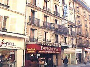 ein Gebäude auf einer Straße mit Leuten, die davor laufen in der Unterkunft Avenir Hotel in Paris