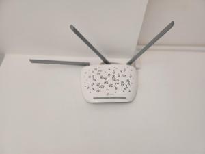 um router branco pendurado no tecto em Txada Hostel em Praia