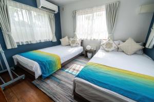 1 Schlafzimmer mit 2 Betten und Regenbogen in der Unterkunft private house noko in Miyako-jima