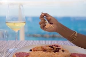 een persoon die eten op een tafel met een glas wijn bij Hotel Rex in Livorno