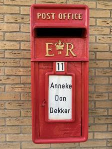 a red post office box on a brick wall at Rose Cottage B&B in Nes