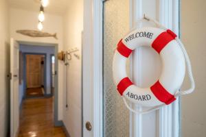 un préservatif rouge et blanc suspendu à une porte dans l'établissement Cosy coastal cottage- Allwood Harbour, à Kiama