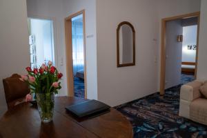 un jarrón de flores sobre una mesa en la sala de estar en Hotel Etol - Superior, en Baden-Baden