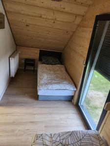 een slaapkamer op zolder met een bed en een raam bij Domek rodzinny in Piekielnik