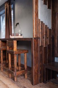 a wooden table with a bench and a table and stool at Гостьовий дім Білий пацюк in Kamianets-Podilskyi