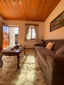 uma sala de estar com um sofá e uma mesa em Zagori Home em Monodendri