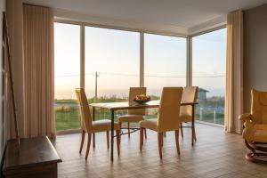 a dining room with a table and chairs and a large window at SilverSide Holidays in Caldas da Rainha