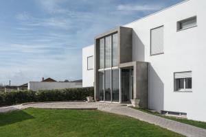 a white house with large windows and a lawn at SilverSide Holidays in Caldas da Rainha