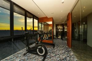 a room with a gym with a treadmill and windows at Nata Azana Hotel Solo in Solo