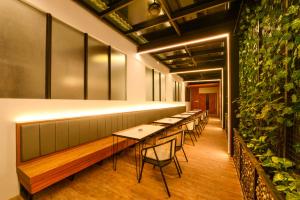 a row of tables and chairs in a room with plants at Nata Azana Hotel Solo in Solo