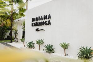 Indiana Kenanga Boutique Hotel & Spa في نوسا ليمبونغان: علامة على جانب مبنى به نباتات