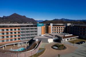 un grupo de edificios con montañas en el fondo en UNAHOTELS Varese, en Varese