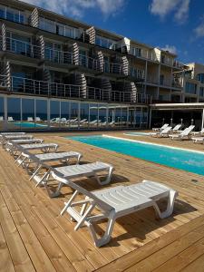 una fila de tumbonas junto a una piscina en Apart-Hotel Poseidon, en Odessa