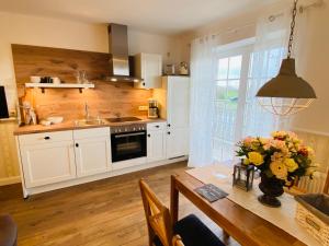 una cocina con una mesa con un jarrón de flores. en Hasselberger Huus, en Hasselberg