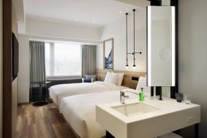 Fairfield by Marriott Osaka Namba في أوساكا: غرفة فندقية بسريرين ومغسلة