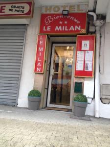 un negozio con due piante in vaso davanti di Hôtel Le Milan a Lourdes