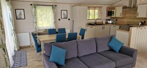 ein Wohnzimmer mit einem Sofa und einem Tisch sowie eine Küche in der Unterkunft Luxury Lodge @ Hoburne Devon Bay in Paignton