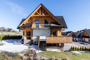 une maison en bois avec un toit en gambrel dans l'établissement Apartament Czorsztyn, à Kluszkowce