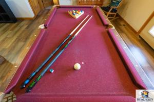 - un billard avec deux cannes et un ballon dans l'établissement Forest Heights Lodge - 6BR - Pool Table - Near Silver Dollar City - FREE TICKETS INCLUDED, à Branson