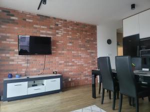 ein Wohnzimmer mit einem Tisch und einer Ziegelwand in der Unterkunft Apartament MAJA (przy Aquaparku w Redzie) in Rumia