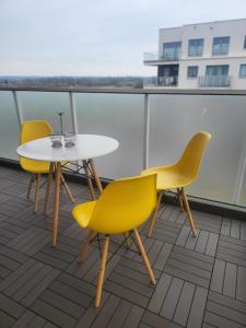 3 Stühle und ein Tisch auf dem Balkon in der Unterkunft Apartament MAJA (przy Aquaparku w Redzie) in Rumia