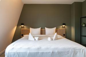 A bed or beds in a room at Hotel de Duif Lisse - Keukenhof