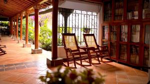 une rangée de chaises dans une bibliothèque avec des étagères dans l'établissement Hotel Villa de Mompox, à Mompos