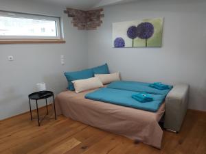 1 dormitorio con cama con sábanas azules y ventana en Penthouse-Feeling MaBeA, en Innsbruck