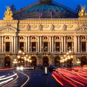 um grande edifício com carros estacionados em frente em Hotel Riviera Renovated em Paris