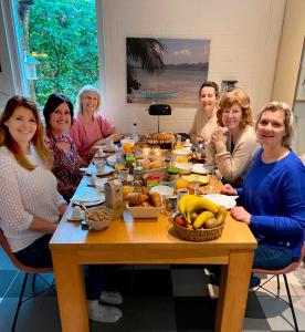 un grupo de personas sentadas alrededor de una mesa con comida en Cottage Markdal, en Breda