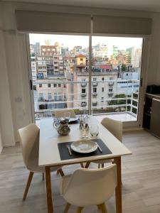 mesa de comedor con sillas y ventana grande en MAO Buenos Aires - Apt. en Recoleta, en Buenos Aires