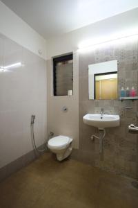 La salle de bains est pourvue de toilettes et d'un lavabo. dans l'établissement Saish Hotel Shirdi, à Shirdi