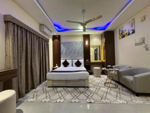 1 dormitorio con cama extragrande y sofá en Al Nakheel Hotel Apartments, en Ras al Khaimah