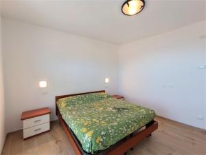 1 dormitorio con 1 cama con edredón verde en Appartamento Lella, en Baveno