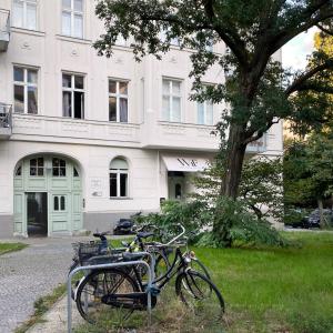 due biciclette parcheggiate accanto a un albero di fronte a un edificio di Wil7 Boutique Hotel a Berlino