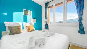 una camera da letto con un grande letto bianco con una parete blu di HOMEY Coloc goodLife - Colocation moderne - Chambres privées - Wifi et Netflix - Au pied du tram pour Genève ad Ambilly