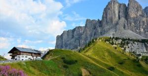 dom na zielonym wzgórzu z górą w obiekcie Rifugio Frara w mieście Selva di Val Gardena